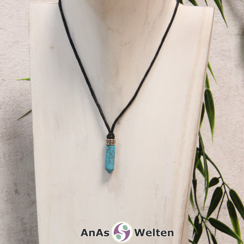 Eine türkiser Turquenit Stift-Anhänger klein Kette mit einem Metallelement über dem Edelstein an einer hellen Büste.