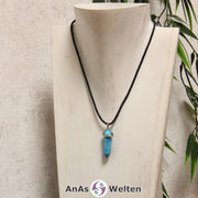 Ein Turquenit Stift-Anhänger groß mit Metallöse, der mit einem schwarzen Baumwollband um eine dunkle Büste gehängt wurde