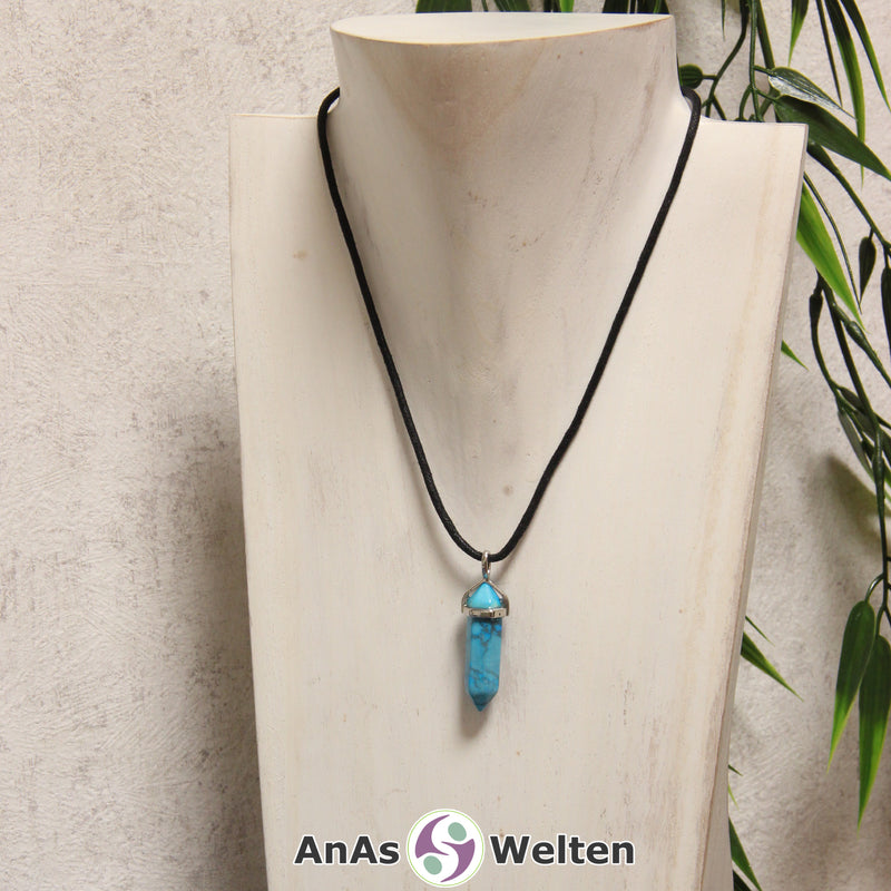 Ein Turquenit Stift-Anhänger groß mit Metallöse, der mit einem schwarzen Baumwollband um eine dunkle Büste gehängt wurde