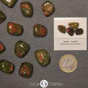 Mehrere Beispiele für den Unakit Trommelstein. Daneben liegt der Sticker.