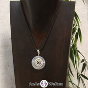 Ein Achat Donut an einem Donut-Halter Spirale, der mit einem gewachsten Baumwollband um eine dunkle Büste hängt.