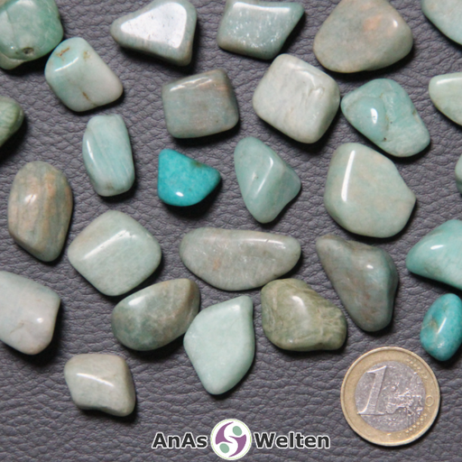 Das Bild zeigt einen Amazonit Trommelstein in verschiedenen Variationen. Man erkennt hier gut die möglichen Farbunterschiede von einer fast weißen Hellblau über ein kräftiges Blaugrün bis hin zu einem Blaubraun.
