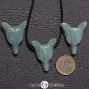 Drei Amazonit Wolf Anhänger nebeneinander. Einer befindet sich an einem schwarzen Baumwollband.