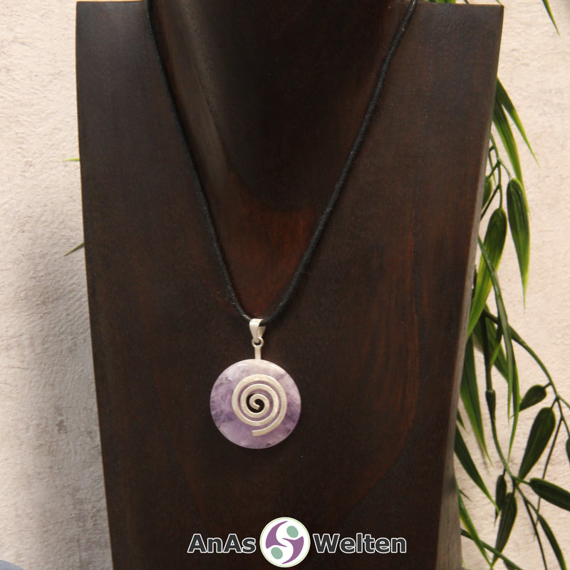 Ein Amethyst Donut an einem Donut-Halter Spirale, der mit einem gewachsten Baumwollband um eine dunkle Büste hängt.