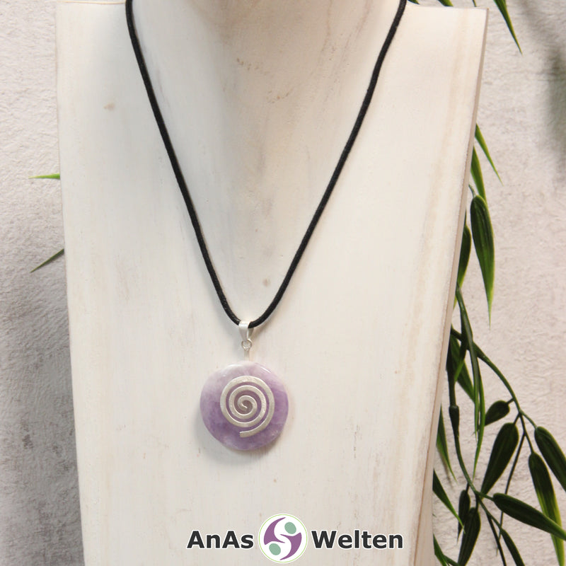 Ein Amethyst Donut an einem Donut-Halter Spirale, der mit einem gewachsten Baumwollband um eine helle Büste hängt.