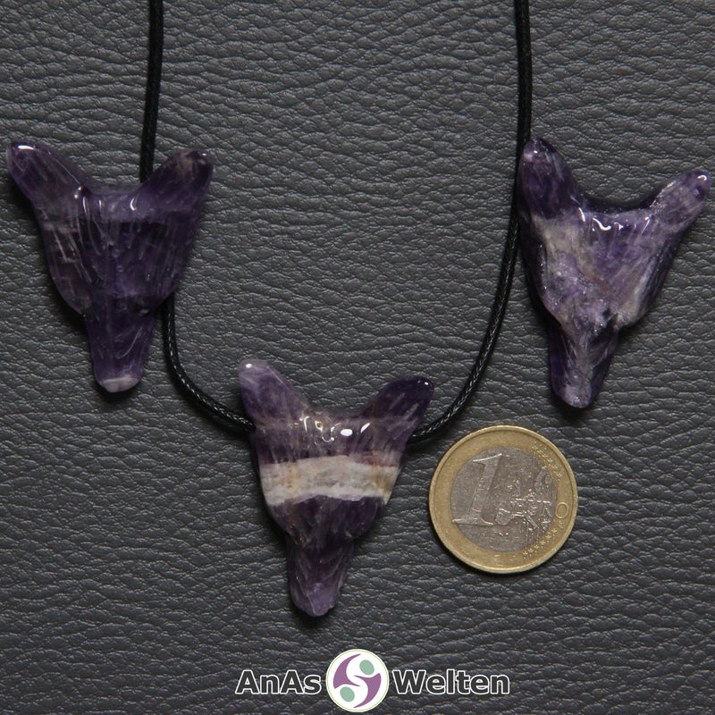 Drei Amethyst Wolf Anhänger nebeneinander. Einer befindet sich an einem schwarzen Baumwollband.