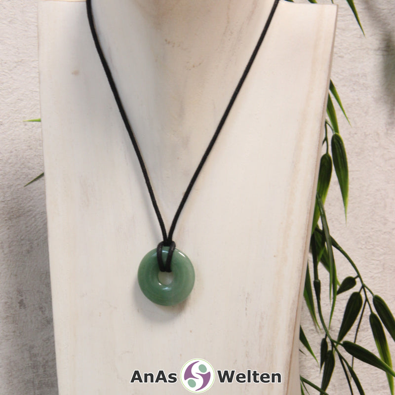Ein Aventurin Donut als Kette an einem schwarzen gewachsten Baumwollband um eine helle Büste.