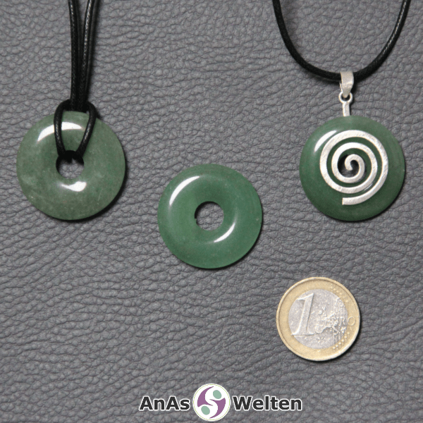 Drei Aventurin Donuts nebeneinander. Einer an einem Baumwollband, ein anderer an einem Donut-Halter mit Baumwollband.