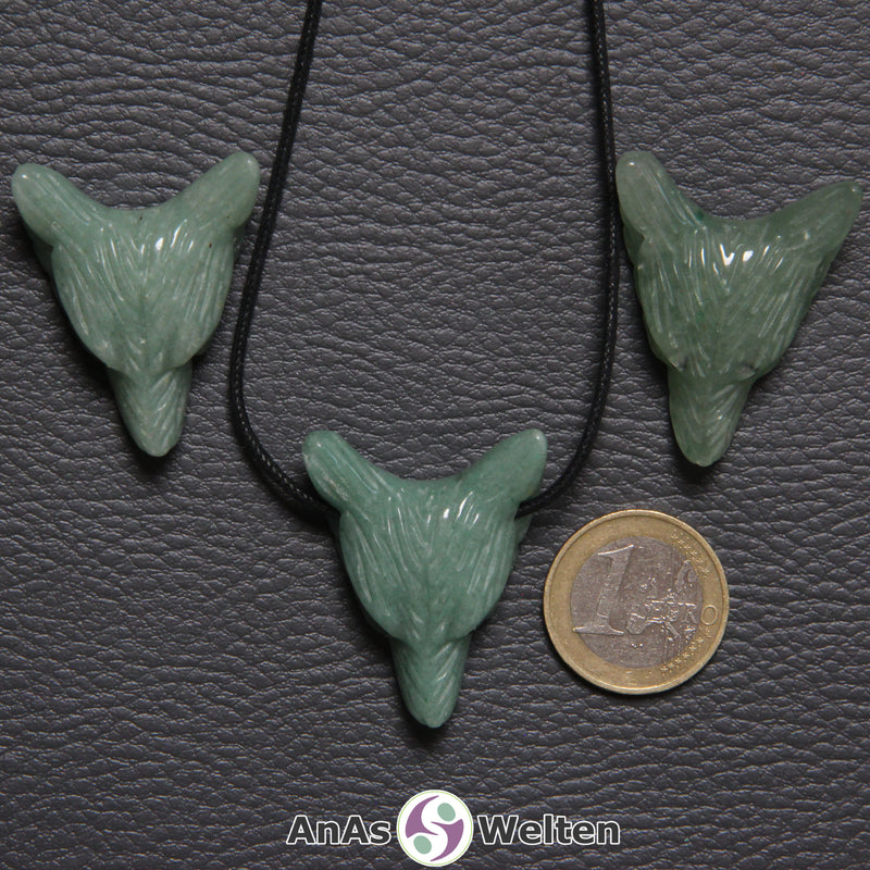 Drei Aventurin Wolf Anhänger nebeneinander. Einer befindet sich an einem schwarzen Baumwollband.