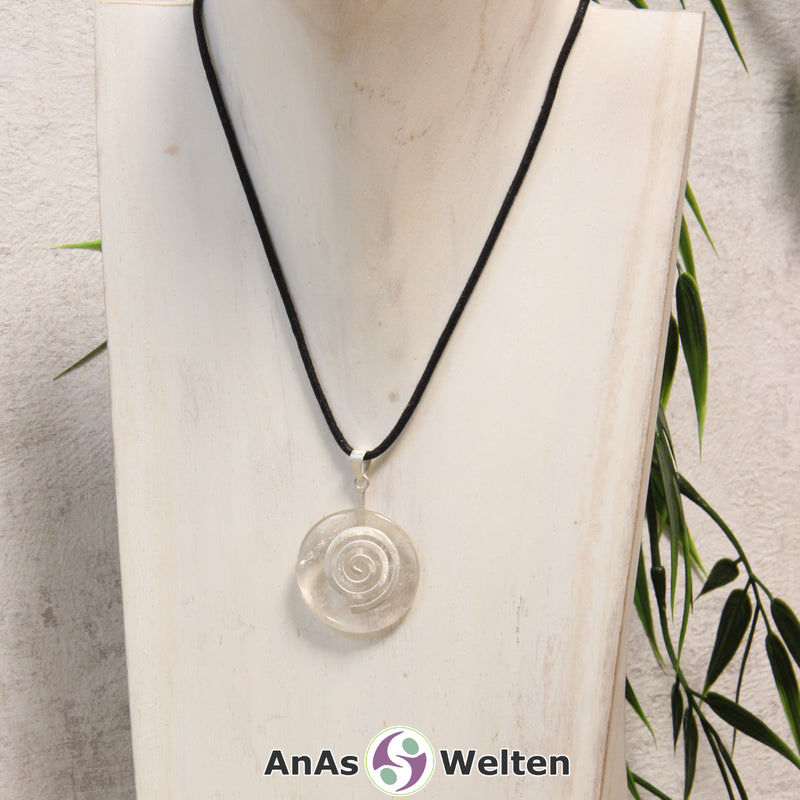 Ein Bergkristall Donut an einem Donut-Halter Spirale, der mit einem gewachsten Baumwollband um eine helle Büste hängt.