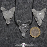 Drei Bergkristall Wolf Anhänger nebeneinander. Einer befindet sich an einem schwarzen Baumwollband.