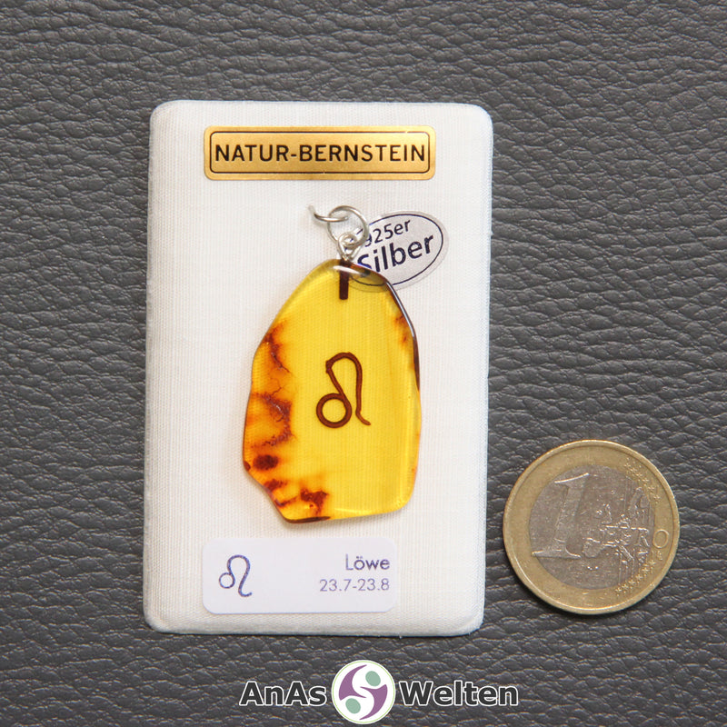 Ein Bernstein Anhänger Löwe mit Silberöse an einem Display. Das Sternzeichen ist in den Bernstein eingebrannt.