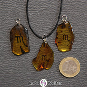 Drei Bernstein Anhänger Skorpion in verschiedenen Formen. Das Sternzeichensymbol ist in die Bernsteine eingebrannt.