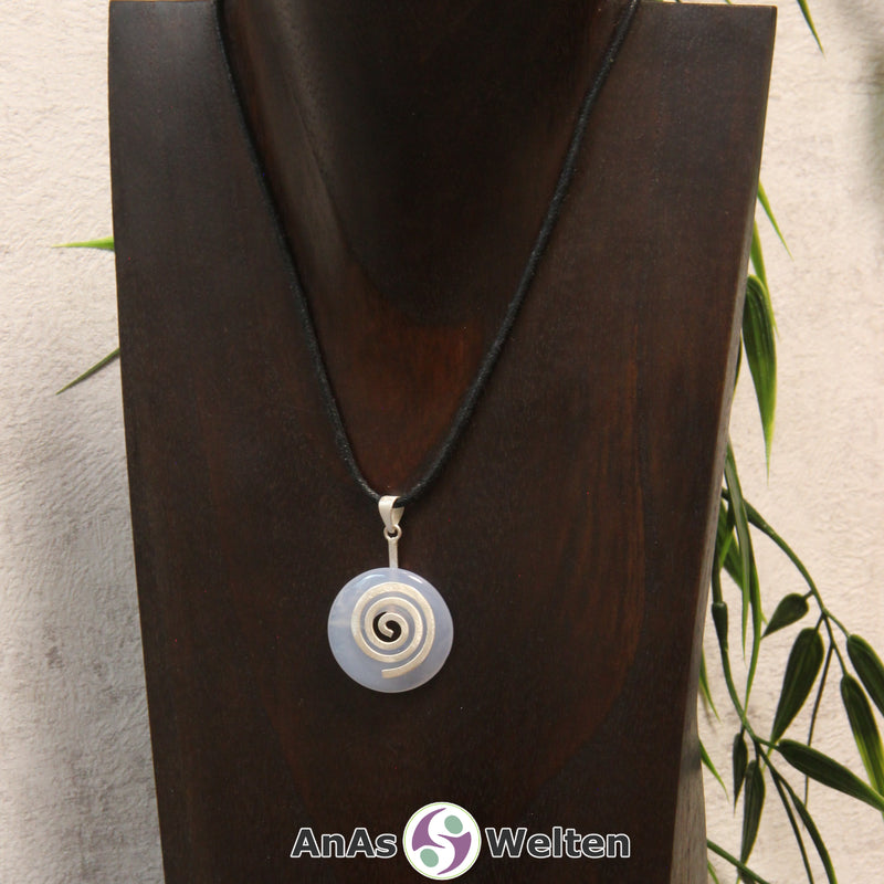 Ein Blauer Chalcedon Donut an einem Donut-Halter Spirale, der mit einem gewachsten Baumwollband um eine dunkle Büste hängt.