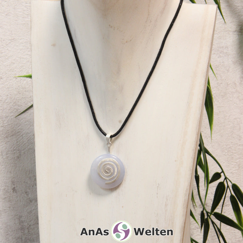 Ein Blauer Chalcedon Donut an einem Donut-Halter Spirale, der mit einem gewachsten Baumwollband um eine helle Büste hängt.