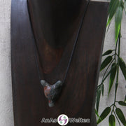 Ein Heliotrop Wolf Anhänger an einem schwarzen Baumwollband, der um eine dunkle Büste gehängt wurde.