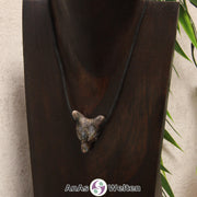 Ein Blue Liberty Wolf Anhänger an einem schwarzen Baumwollband, der um eine dunkle Büste gehängt wurde.