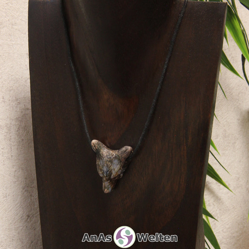 Ein Blue Liberty Wolf Anhänger an einem schwarzen Baumwollband, der um eine dunkle Büste gehängt wurde.