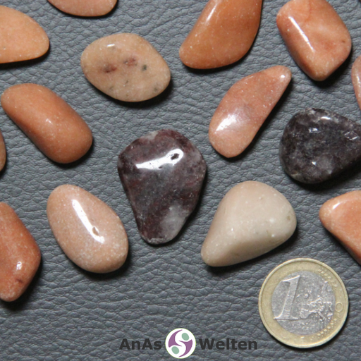 Das Bild zeigt den Dolomit Trommelstein in mehreren Beispielen. Die meisten Edelsteine haben eine sandige rotbraune Färbung. Einige von ihnen sind hingegen beige und andere dunkelrot bis schwarz mit grau-beigen Einschlüssen.