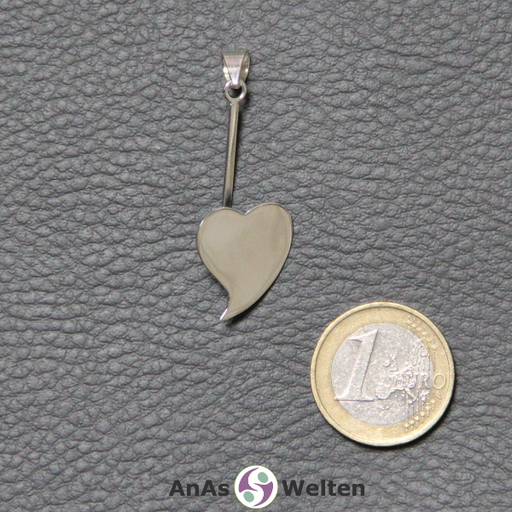 Der Donut-Halter Herz aus Silber hat einen gebogenen Stab, in den der Edelsteindonut eingehängt werden kann. Am oberen Ende befindet sich eine Öse für eine Kette oder ein Band, während am unteren Ende ein großes, flaches, geschwungenes Herz befestigt ist.