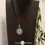 Ein Dumortierit Donut an einem Donut-Halter Spirale, der mit einem gewachsten Baumwollband um eine dunkle Büste hängt.