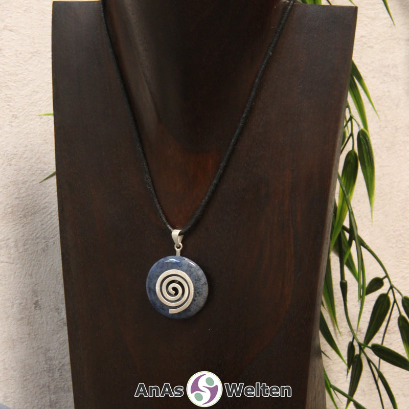 Ein Dumortierit Donut an einem Donut-Halter Spirale, der mit einem gewachsten Baumwollband um eine dunkle Büste hängt.