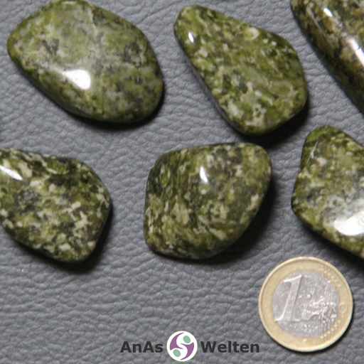 Das Bild zeigt einen Epidot Trommelstein in mehreren Beispielen. Die Edelsteine sind hell- und dunkelgrün gefleckt, was auch ihre Musterung ausmacht.