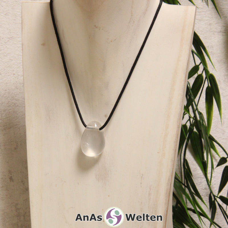 Ein dursichtiger Girasol gebohrter Trommelstein an einem schwarzen Baumwollband, der um eine helle Büste gehängt wurde.