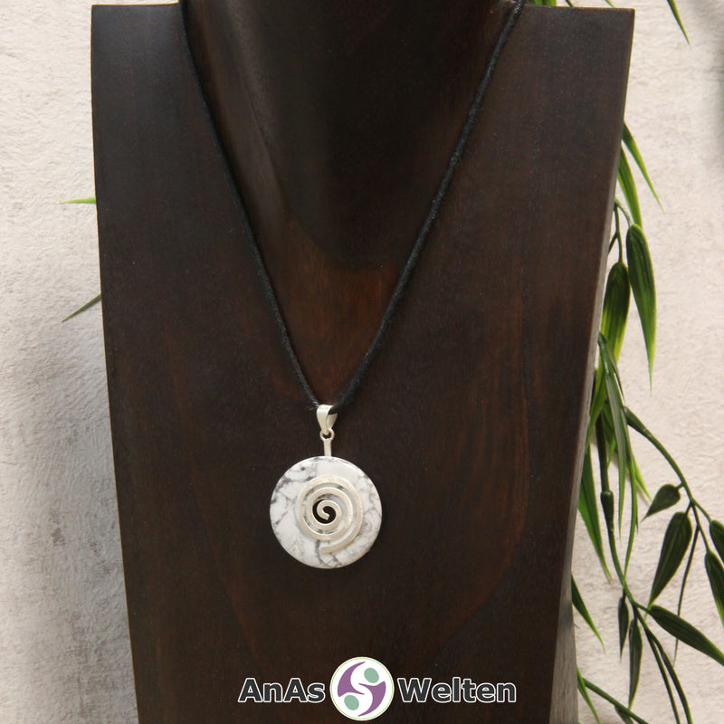 Ein Magnesit Donut an einem Donut-Halter Spirale, der mit einem gewachsten Baumwollband um eine dunkle Büste hängt.