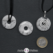 Drei Magnesit Donuts nebeneinander. Einer an einem Baumwollband, ein anderer an einem Donut-Halter mit Baumwollband.