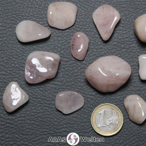Das Bild zeigt einen Morganit Trommelstein anhand mehrerer Beispielsteine. Die Edelsteine haben eine zartrosa Farbe und eine schwache Musterung aus unterschiedlichen Rosatönen.