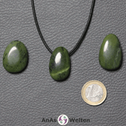 Drei grüne Nephrit Jade gebohrte Trommelsteine nebeneinander. Einer befindet sich an einem schwarzen gewachsten Baumwollband.