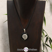 Ein Onyx Donut an einem Donut-Halter Spirale, der mit einem gewachsten Baumwollband um eine dunkle Büste hängt.