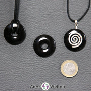 Drei Onyx Donuts nebeneinander. Einer an einem Baumwollband, ein anderer an einem Donut-Halter mit Baumwollband.