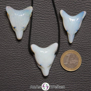 Drei Opalglas Wolf Anhänger nebeneinander. Einer befindet sich an einem schwarzen Baumwollband.