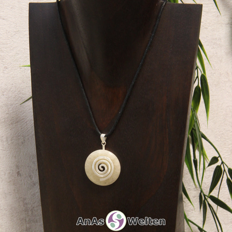 Ein Orangencalcit Donut an einem Donut-Halter Spirale, der mit einem gewachsten Baumwollband um eine dunkle Büste hängt.