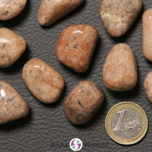 Das Bild zeigt einen Orthoklas Trommelstein anhand mehrerer Beispielsteine. Die Edelsteine sind allesamt undurchsichtig und haben eine Mischung aus beigen, braunen, orangenen und grauen Farben. Der größte Anteil hierbei ist beige-orange.