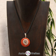 Ein Roter Jaspis Donut an einem Donut-Halter Spirale, der mit einem gewachsten Baumwollband um eine dunkle Büste hängt.