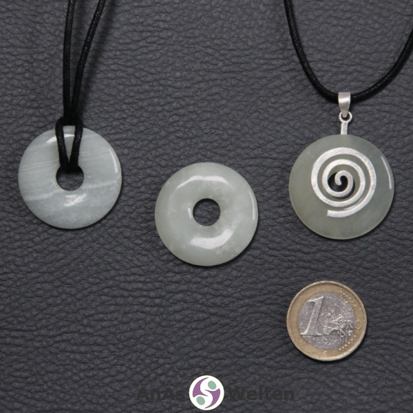 Ein Sodalith Donut an einem Donut-Halter Spirale, der mit einem gewachsten Baumwollband um eine helle Büste hängt.