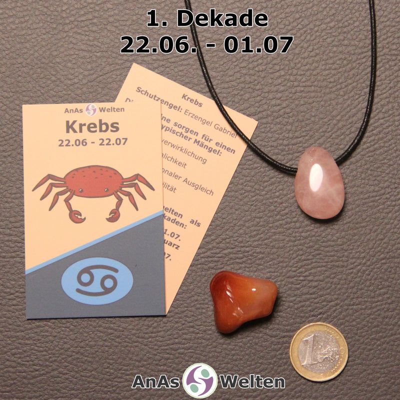 Die Sternzeichenkarte und je ein beispielhafter gebohrter Rosenquarz Trommelstein am Band und ein Karneol Trommelstein der 1. Dekade liegen nebeneinander.