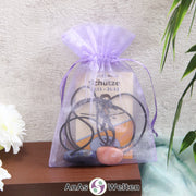 Ein beispielhaftes Sternzeichen Steine Set Schütze mit Karte, Trommelstein und Edelsteinkette in einem lila Organzabeutel.