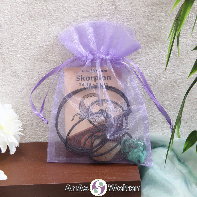 Ein beispielhaftes Sternzeichen Steine Set Skorpion mit Karte, Trommelstein und Edelsteinkette in einem lila Organzabeutel.