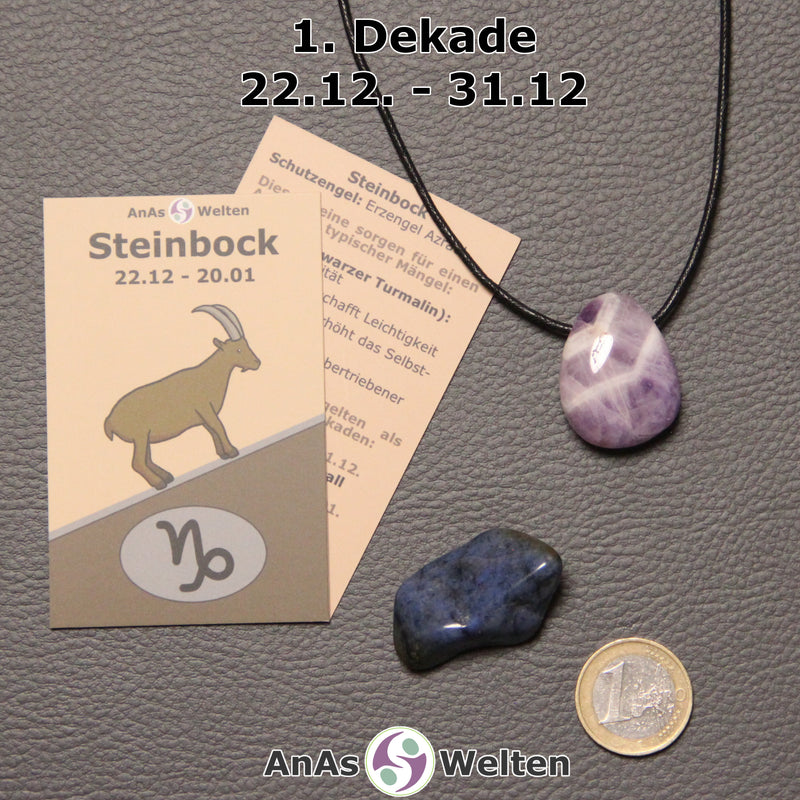 Die Sternzeichenkarte und je ein beispielhafter gebohrter Amethyst Trommelstein am Band und ein Dumortierit Trommelstein der 1. Dekade liegen nebeneinander.