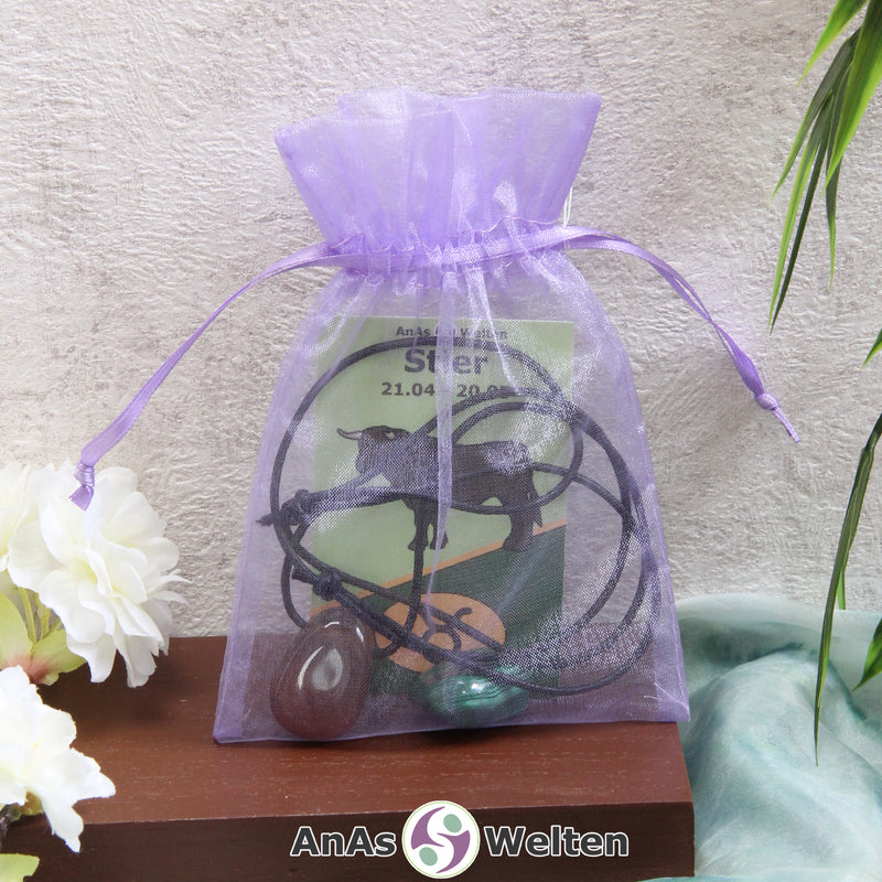 Ein beispielhaftes Sternzeichen Steine Set Stier mit Karte, Trommelstein und Edelsteinkette in einem lila Organzabeutel.