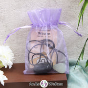 Ein beispielhaftes Sternzeichen Steine Set Waage mit Karte, Trommelstein und Edelsteinkette in einem lila Organzabeutel.