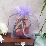 Ein beispielhaftes Sternzeichen Steine Set Widder mit Karte, Trommelstein und Edelsteinkette in einem lila Organzabeutel.