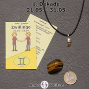 Die Sternzeichenkarte und je ein beispielhafter Goldtopas mit Öse am Band und ein Tigerauge Trommelstein der 1. Dekade liegen nebeneinander.