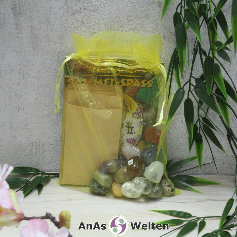 Das Maulwurf Trommelsteine Set mit Edelsteinen, Heft, Stickern und Tüten in einem gelben Organzasäckchen.