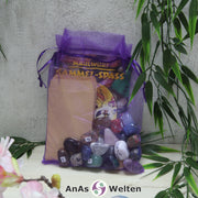 Das Maulwurf Trommelsteine Set mit Edelsteinen, Heft, Stickern und Tüten in einem lila Organzasäckchen.