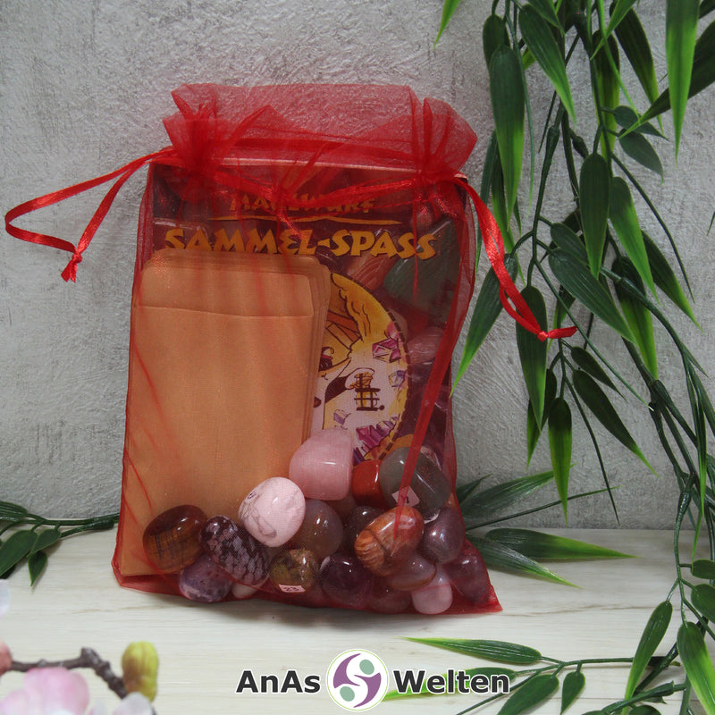 Das Maulwurf Trommelsteine Set mit Edelsteinen, Heft, Stickern und Tüten in einem roten Organzasäckchen.